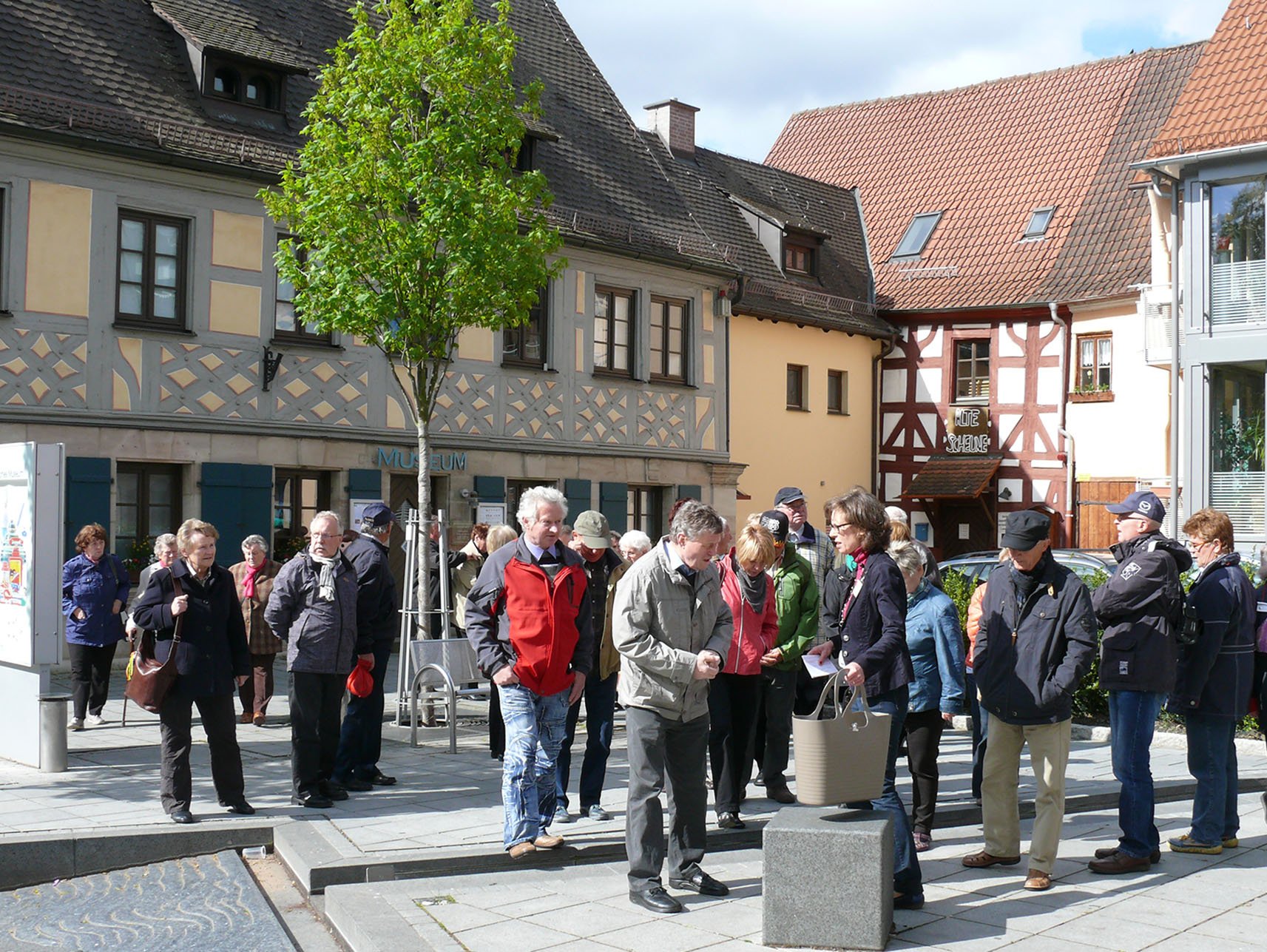 Teilnehmerinnen und Teilnehmer einer Stadtführung auf dem Platz vor dem Museum